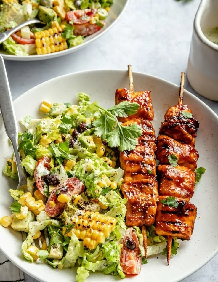 BBQ chicken skewer salad with grilled chicken, fresh vegetables, and dressing