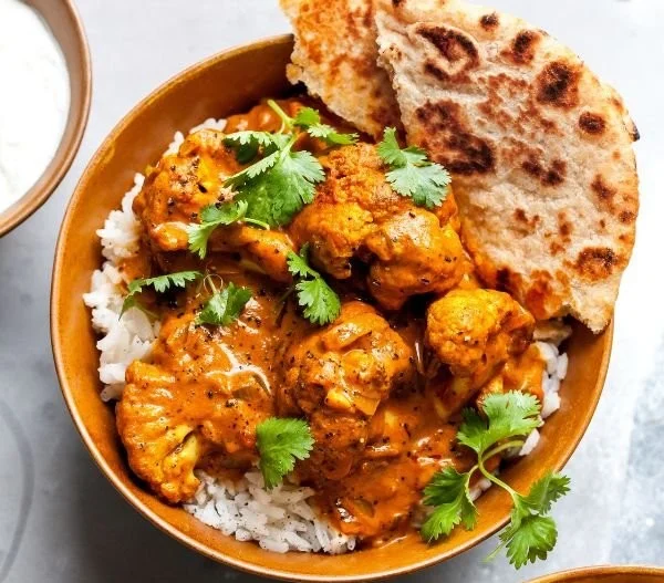 Creamy butter cauliflower dish topped with spices and herbs