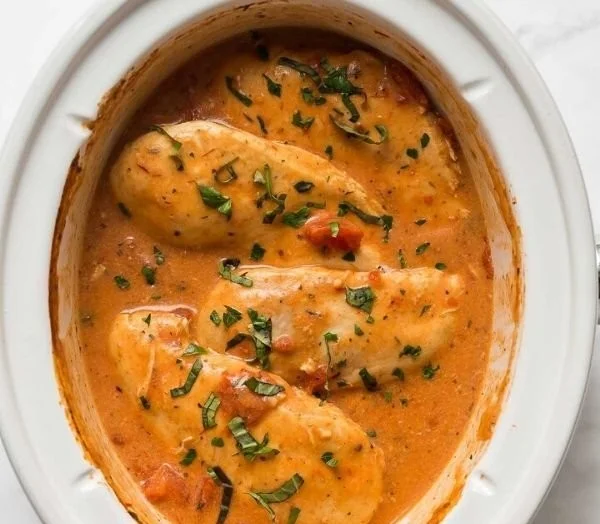 Creamy tomato basil chicken in a slow cooker dish ready to serve