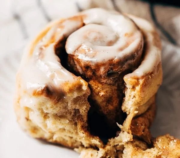 Delicious gluten free cinnamon rolls with creamy frosting on a wooden table