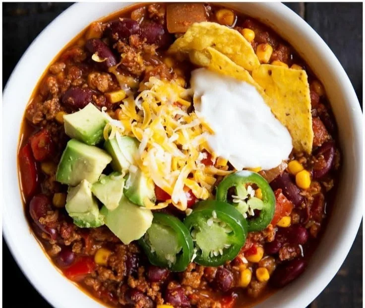 Bowl of healthy turkey chili topped with fresh herbs and spices