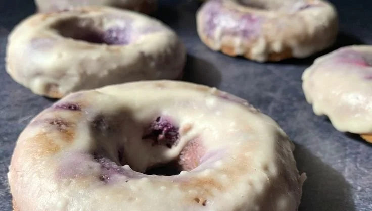 High-protein blueberry cake donuts on a rustic wooden table