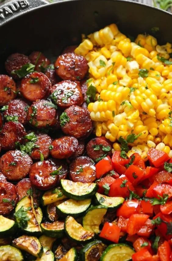 Sausage and veggies skillet recipe prepared in a colorful cast iron pan.