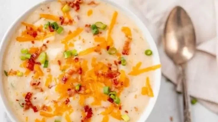 Bowl of Slow Cooker Loaded Potato Soup topped with cheese and green onions