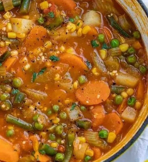 Bowl of colorful vegetable soup garnished with herbs